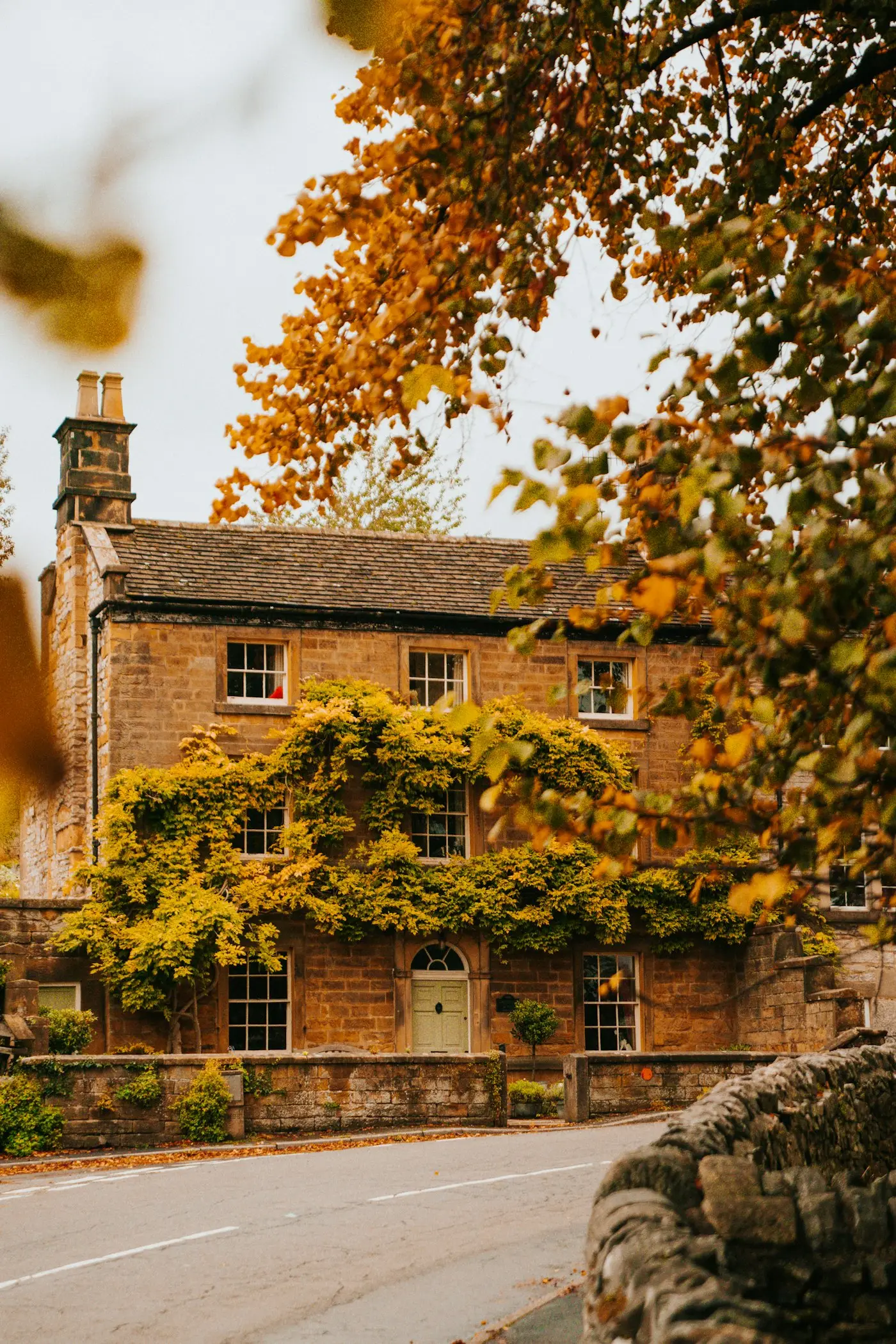 Stone farmhouse beside an autumn tree
